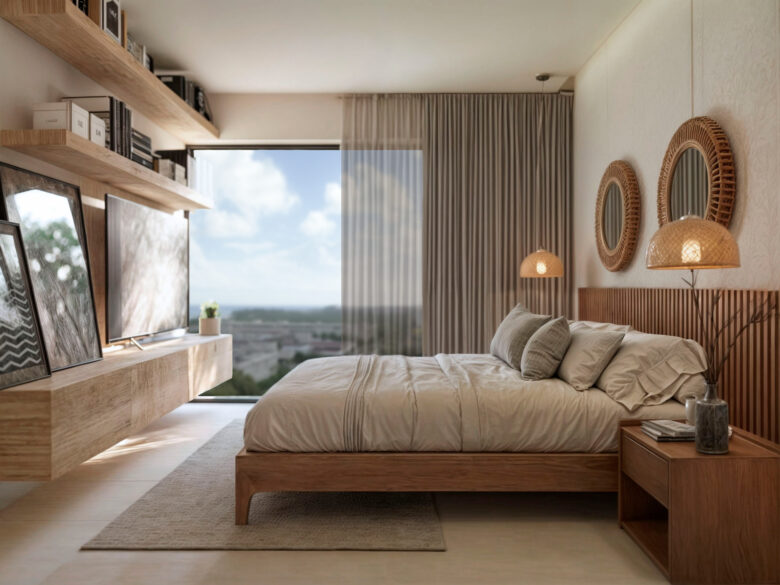 Habitación principal del desarrollo Macondo Punta Esmeralda con cama de madera, espejos decorativos redondos, lámparas tejidas, estantes flotantes y gran ventanal con vista al exterior, parte de los departamentos en venta en Playa del Carmen.