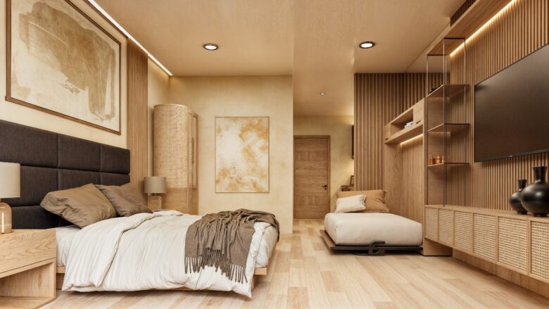 Interior de unidad en Macondo Corazón con cama abatible (Murphy), mobiliario de madera natural, iluminación cálida, arte contemporáneo en tonos neutros y ventanal hacia la terraza. Espacio moderno y versátil dentro de los departamentos en venta en Playa del Carmen.